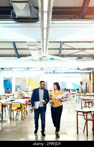 Lavorano sodo per fare un passo avanti nel business. Due progettisti discutono in ufficio. Foto Stock