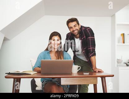 Perché dovremmo lavorare altrove? Ritratto di una coppia felice di imprenditori che lavorano insieme dal loro ufficio domestico. Foto Stock