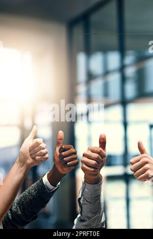 Continuate il lavoro fantastico. Un gruppo di uomini d'affari irriconoscibili che gestiva i pollici. Foto Stock