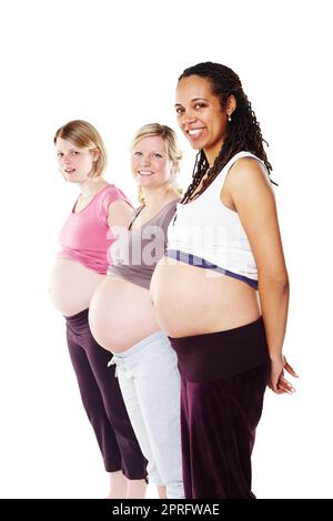 Gruppo di donne incinte in fila con pancia, stomaco e pancia mostrando per maternità, assistenza sanitaria e maternità su uno sfondo bianco studio. Ritratto della comunità della diversità di mamme felici eccitate Foto Stock