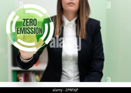 Testo calligrafico Zero Emission (emissioni zero). Foto concettuale Engine Motor Energy Source che non emette sprechi di prodotti donna d'affari che tiene un telefono cellulare con messaggi importanti seduti sulla scrivania. Foto Stock