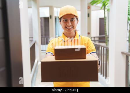 la signora postale consegna la cassetta postale di fronte alla casa. Foto Stock