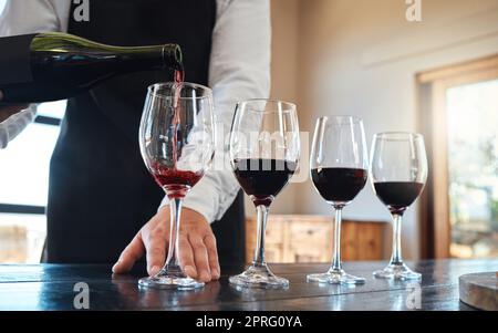 Degustazione di vini rossi con bevande alcoliche di lusso e qualità in bicchieri per il settore gastronomico, gastronomico o alberghiero. Servizio sommelier o drink alcolici vintage in un classico ristorante di classe Foto Stock