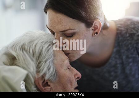 L'amore tra una madre e una figlia, una figlia che visita la madre anziana in ospedale. Foto Stock