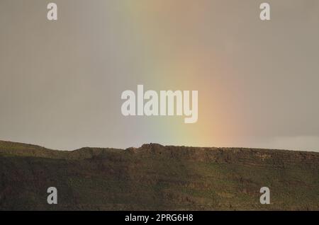 Arcobaleno su una cresta del cratere Tirajana. Foto Stock