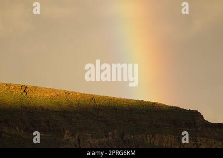 Arcobaleno su una cresta del cratere Tirajana. Foto Stock