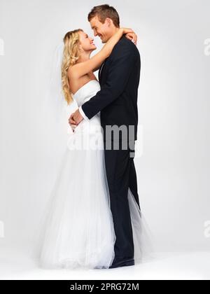 Coppia e matrimonio con una felice sposa e sposo in studio su sfondo bianco. Vestiti, abiti e matrimonio con un uomo e una donna che si sposano in occasione di una festa o di una cerimonia Foto Stock