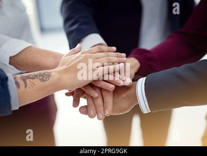 Il rischio più grande è non correre alcun rischio: Un team di colleghi che si uniscono le mani in un'unica unità. Foto Stock