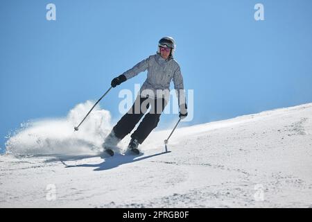 Lo sciatore scivola velocemente su una pista innevata Foto Stock