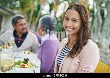 Più felice a casa. Ritratto corto di una giovane donna che ha pranzo con i suoi genitori fuori. Foto Stock