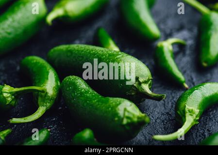 Peperoni Jalapeno verdi su fondo in cemento scuro Foto Stock