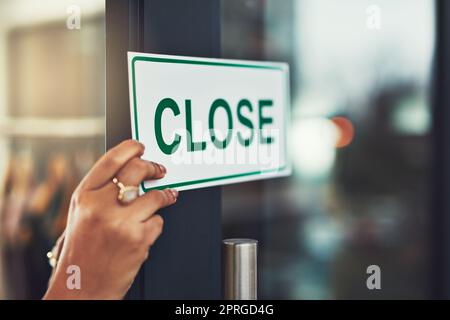 Siamo spiacenti, sono stati chiusi. Primo piano di un giovane imprenditore appendere un segno vicino sulla porta del suo negozio. Foto Stock