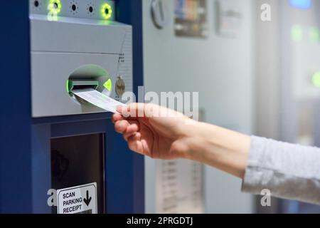 Il parcheggio custodito ha il suo prezzo: Una persona irriconoscibile che inserisce un biglietto in un metro. Foto Stock