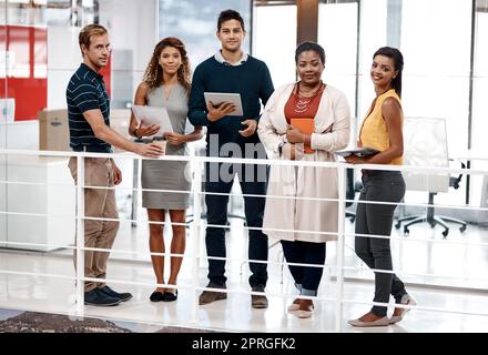 Stare forte per i nostri sogni. Scatto completo di un gruppo di colleghi che si trovano in ufficio e sorridono alla fotocamera. Foto Stock