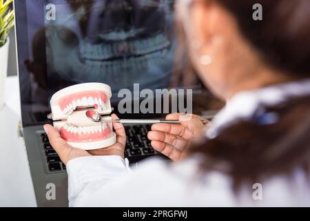 Dentista modello di dente bianco sano e strumento specchio explorer in dentista che spiega al paziente Foto Stock