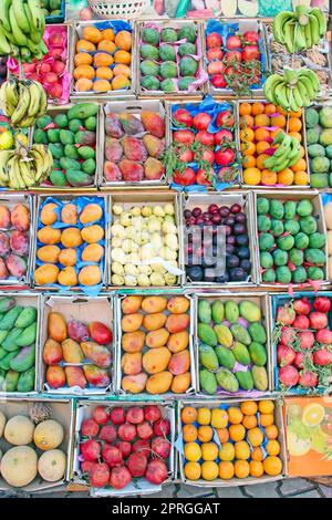 Vassoi di frutta per la vendita di manghi, melograni, banane, prugne, guava, arance Foto Stock