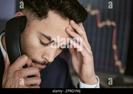 Sottolineato uomo d'affari al telefono, il commercio sul mercato azionario durante una crisi finanziaria. Commerciante in un mercato dell'orso con gli stock che crashing. Crash del mercato A. Foto Stock