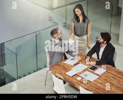 Siamo stati molto contenti di averla a bordo, due uomini d'affari hanno agitato le mani durante una riunione in ufficio. Foto Stock