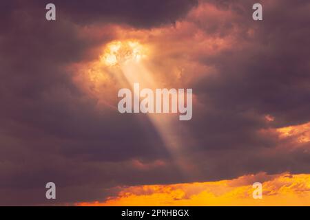 Sole all'alba cielo luminoso drammatico. Raggio del sole attraverso le nuvole piovose scure. Scenografico cielo colorato a Dawn. Tramonto cielo naturale Abstract sfondo Foto Stock