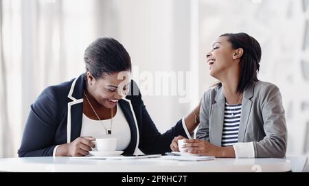 Ci si può divertire in ufficio. Due giovani donne d'affari che si divertono a ridere mentre lavorano insieme in ufficio. Foto Stock