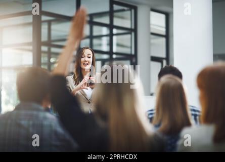 Shell rispondete al maggior numero possibile di domande. Una giovane donna d'affari che fa domande durante una presentazione in sala riunioni. Foto Stock