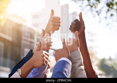 Fate grande. Un gruppo di mani che mostrano i pollici in su. Foto Stock