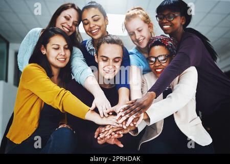 Il nostro stare insieme è ciò che ci fa lavorare. Inquadratura ad angolo basso di un gruppo di colleghi che impilano le mani l'una sull'altra. Foto Stock