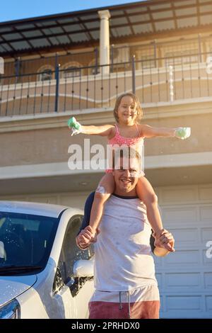 Sentirsi in cima al mondo. Ritratto di un padre che porta la figlia sulle spalle. Foto Stock