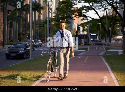 È tempo di pedalare. Un uomo d'affari che si mette in viaggio per lavorare con la sua bicicletta Foto Stock