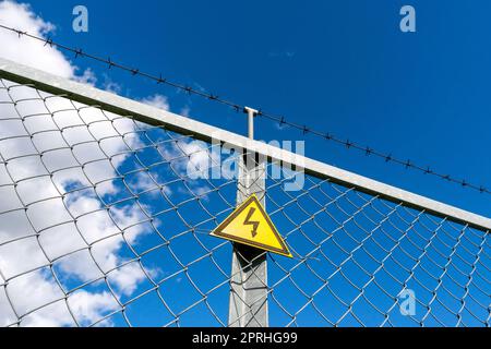 Segnale di avvertimento pericolo sulla recinzione Foto Stock
