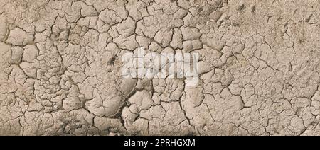 Sfondo di marrone secco incrinato terreno sporco o Terra durante la siccità. Terra secca incrinata che raffigura condizioni di siccità gravi. Panorama Foto Stock