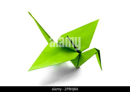 Origami di gru di carta verde isolato su sfondo bianco Foto Stock