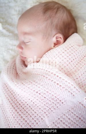 Caldo e accogliente nel suo blankie. Una bella bambina che dorme mentre si avvolge in una coperta Foto Stock