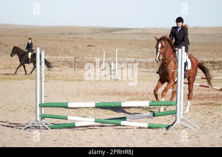 Non seguire i tuoi sogni, inseguirli. due cavalieri guidano i loro cavalli attraverso il dressage Foto Stock