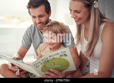 Genitori, bambini e leggere libri di dinosauro in casa di famiglia per divertimento educativo, apprendimento e felice sviluppo in Australia. Mamma, papà e bambino che giocano, l Foto Stock