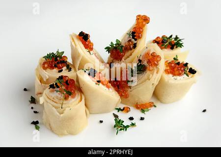 Vista ravvicinata di frittelle con salmone e caviale sulla grande piastra bianca Foto Stock