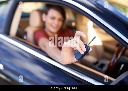 Prendiamo questo per un giro. Primo piano di una donna seduta in un'auto che tiene i tasti fino alla telecamera Foto Stock