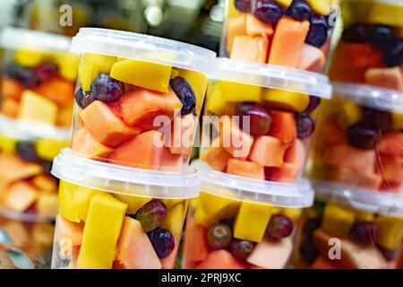 Macedonie di frutta preconfezionate esposte in un frigorifero commerciale Foto Stock