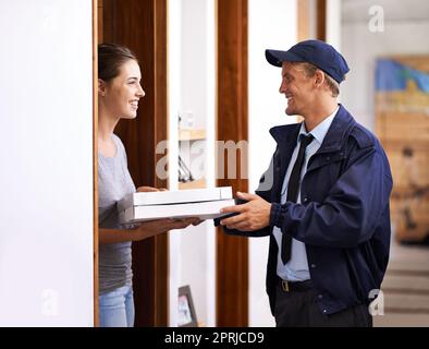 Arriva sempre in orario. un corriere che effettua una consegna a un cliente sorridente Foto Stock