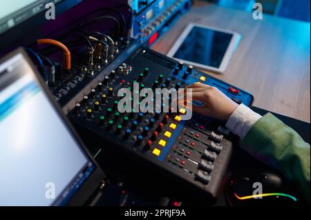 Closeup audio engineer mixare manualmente il suono Foto Stock