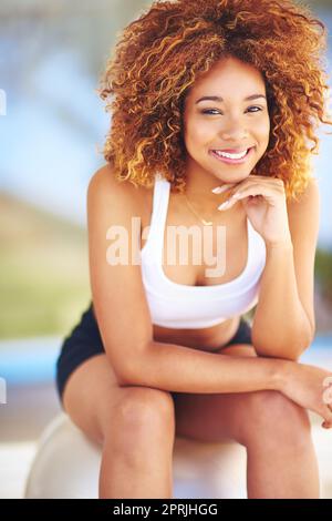 Tutto quello che ti serve è tutto quello che hai. Una giovane donna sportiva seduta su una palla svizzera. Foto Stock