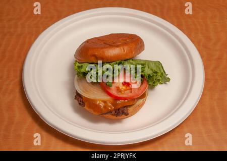 Delizioso cheeseburger con tutti i fissaggi su un panino Foto Stock