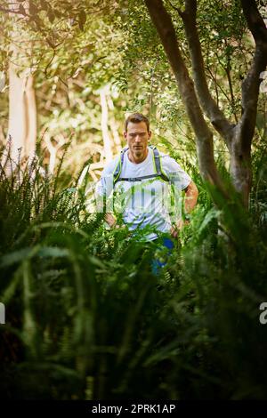 Trail running - un ottimo modo per godersi la natura. Un giovane che corre lungo un sentiero natura. Foto Stock