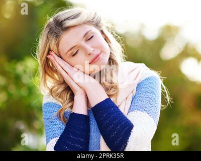 Il suo tempo per un po 'di sonno. Una giovane donna gesturante che il suo tempo per dormire all'aperto. Foto Stock