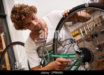 Risolvere le cose è quello che faccio meglio. un giovane e sicuro riparatore di biciclette Foto Stock