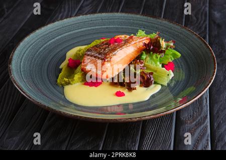 Fritti di filetto di salmone con foglie di insalata e salsa di panna e decorate con caviale Foto Stock