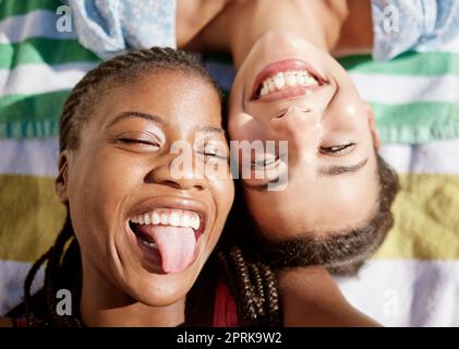 Picnic, estate e le amiche che si rilassano su una coperta all'aperto, folle lingua e divertirsi insieme. Donna nera, sorridere e felice lgbtq coppia posa Foto Stock