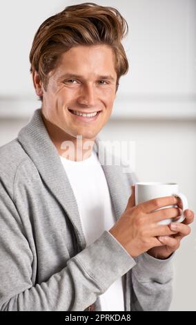 Inizia la giornata con una caffeina. Un bel giovane che tiene una tazza di caffè Foto Stock