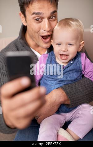 Lascia fare le facce sciocco per questo. Un padre che prende un autoritratto di se stesso e della sua bambina Foto Stock