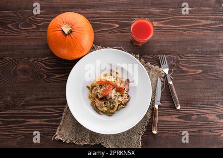 Pasta con pollo, funghi di ostrica e zucca secca al sole Foto Stock